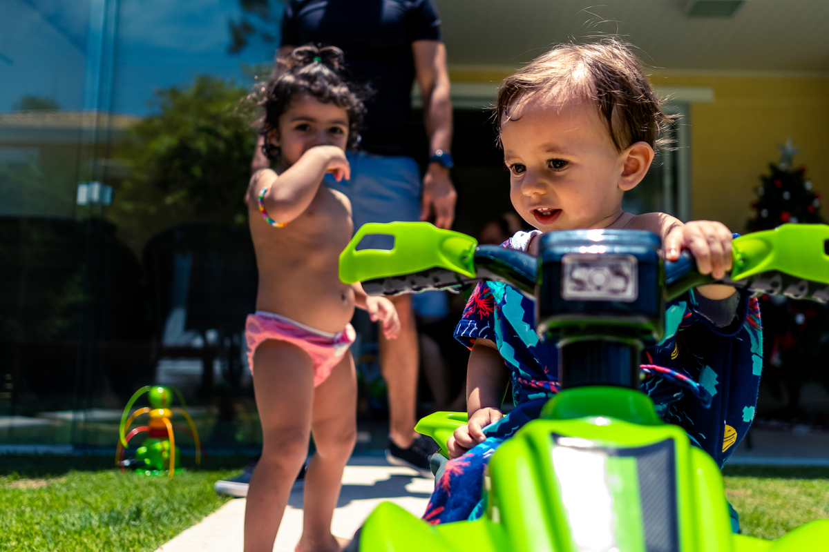 Fotografia Documental de Família em Cotia, Granja Viana, São Paulo, família Galli com filho, bebê, criança de um ano de idade. Momentos em família no café da manhã e brincando com as crianças com água. Bateria completa com os filhos.