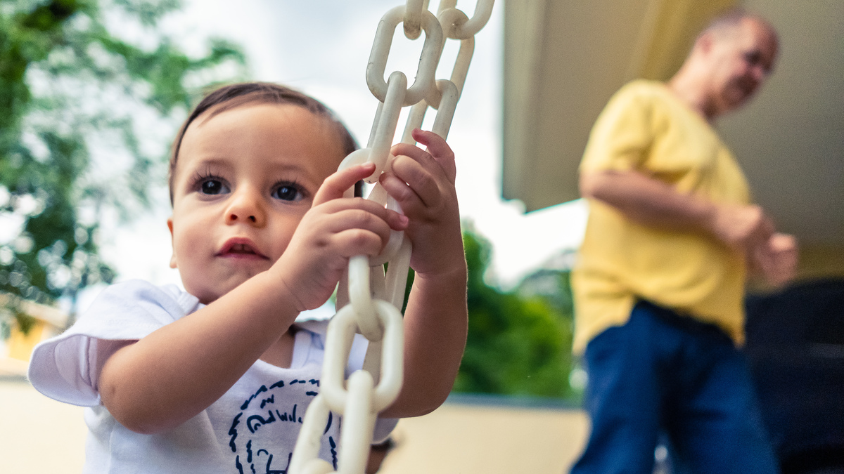 Fotografia Documental de Família em Cotia, Granja Viana, São Paulo, família Galli com filho, bebê, criança de um ano de idade. Momentos em família no café da manhã e brincando com as crianças com água. Bateria completa com os filhos.