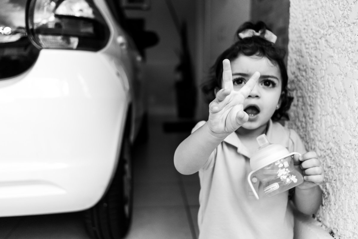 Fotografia Documental de Família em Cotia, Granja Viana, São Paulo, família Galli com filho, bebê, criança de um ano de idade. Momentos em família no café da manhã e brincando com as crianças com água. Bateria completa com os filhos.