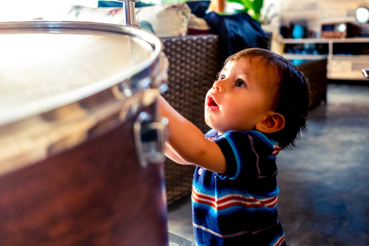 Fotografia Documental de Família em Cotia, Granja Viana, São Paulo, família Galli com filho, bebê, criança de um ano de idade. Momentos em família no café da manhã e brincando com as crianças com água. Bateria completa com os filhos.