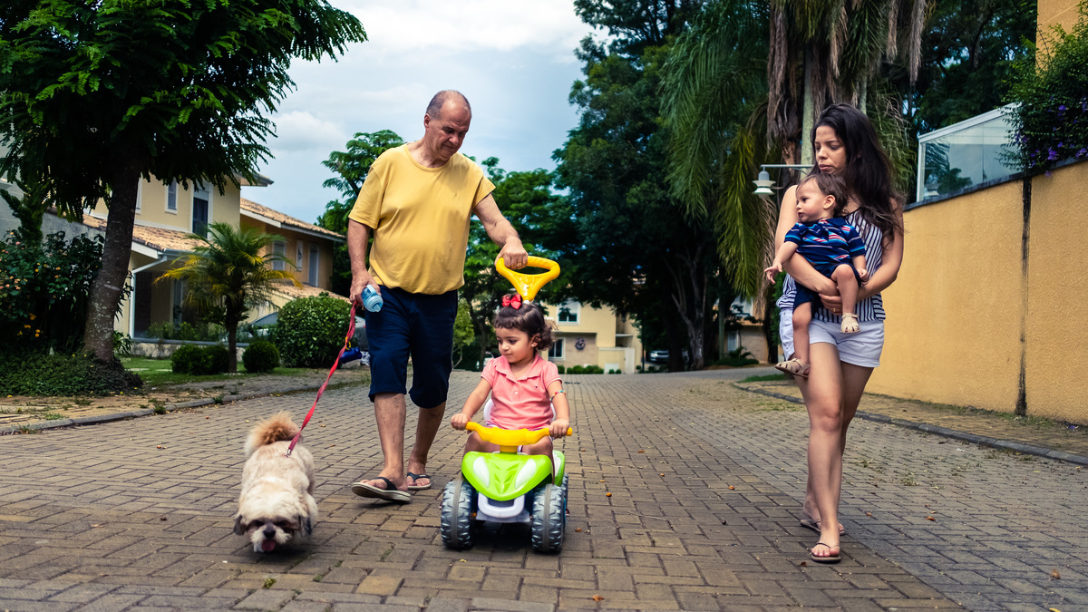 Fotografia Documental de Família em Cotia, Granja Viana, São Paulo, família Galli com filho, bebê, criança de um ano de idade. Momentos em família no café da manhã e brincando com as crianças com água. Bateria completa com os filhos.