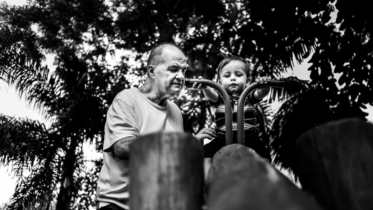 Fotografia Documental de Família em Cotia, Granja Viana, São Paulo, família Galli com filho, bebê, criança de um ano de idade. Momentos em família no café da manhã e brincando com as crianças com água. Bateria completa com os filhos.