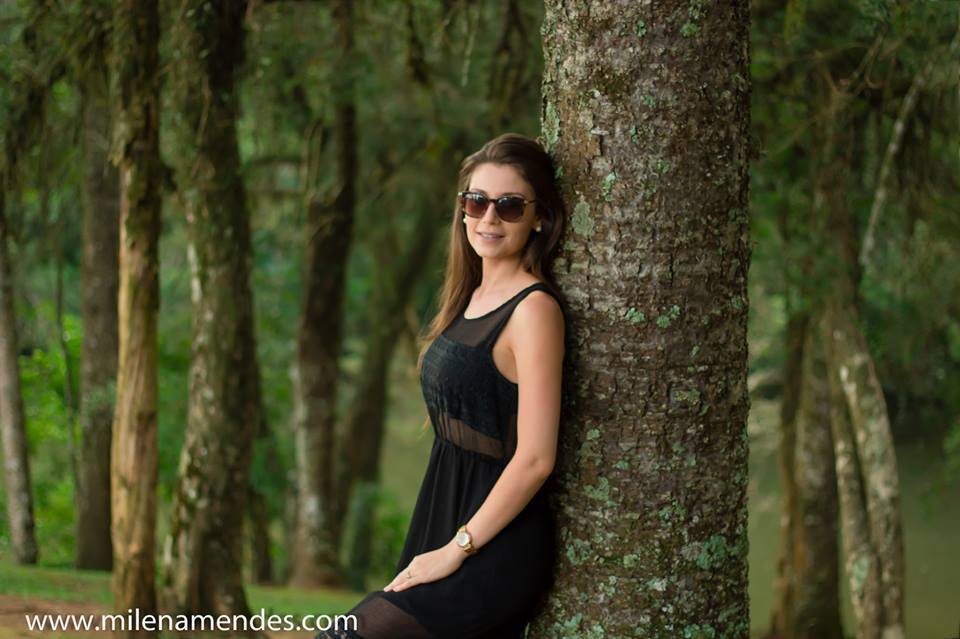 Book feminino Curitiba Milena Mendes, mulher posa pra foto com várias árvores em volta e um rio, e com óculos de sol