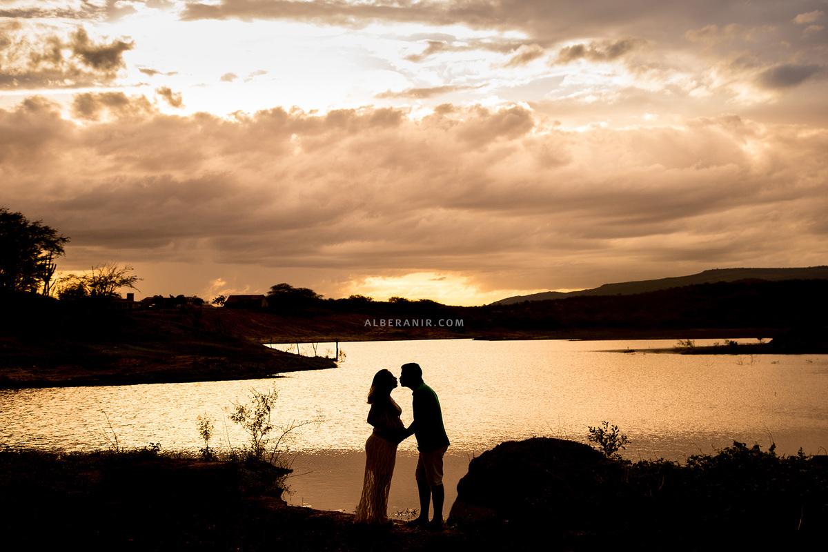 Silhueta no por do sol gestante e esposo.