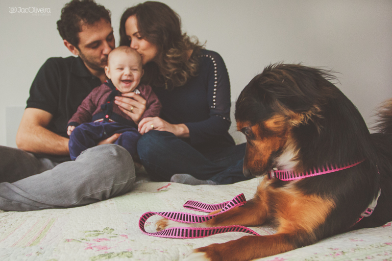 pais com bebê na cama e cadela