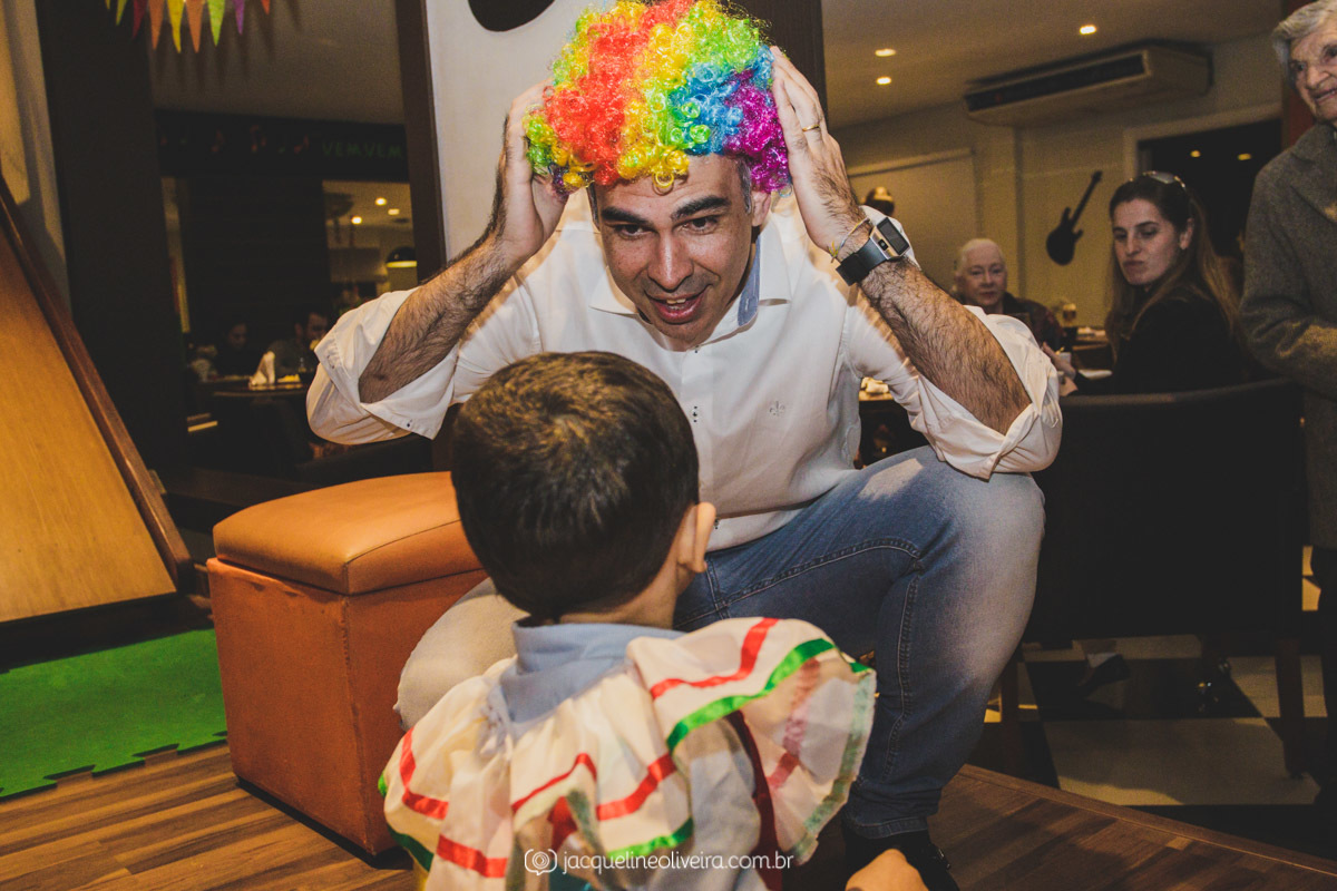 pais brincando com peruca de palhaço