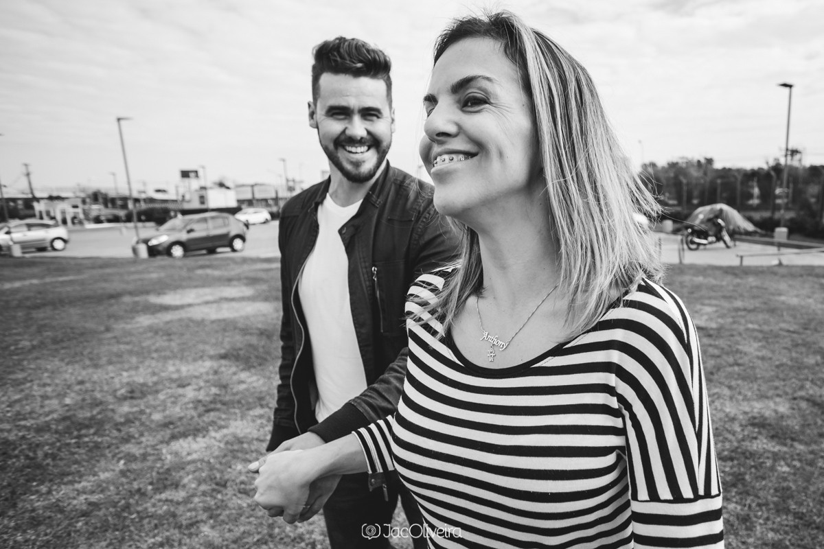 mulher rindo e homem seguindo atrás