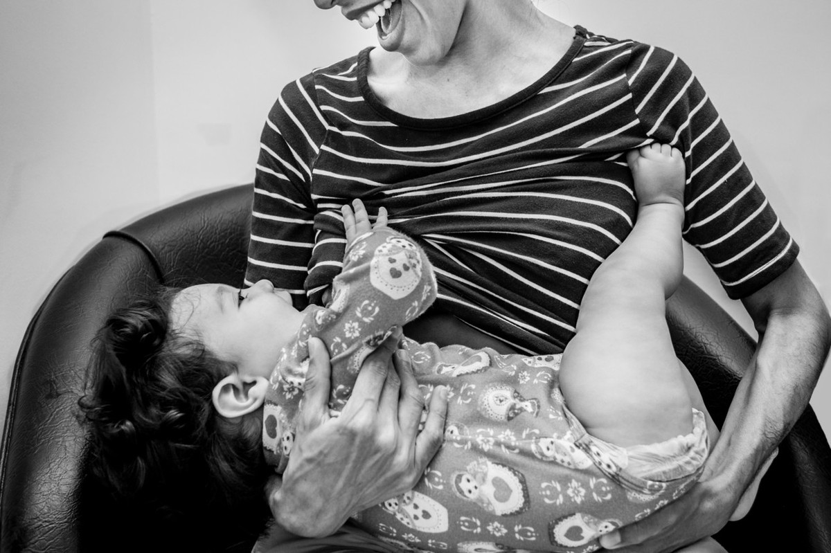 isa mamando na mãe durante ensaio de familia lifestyle