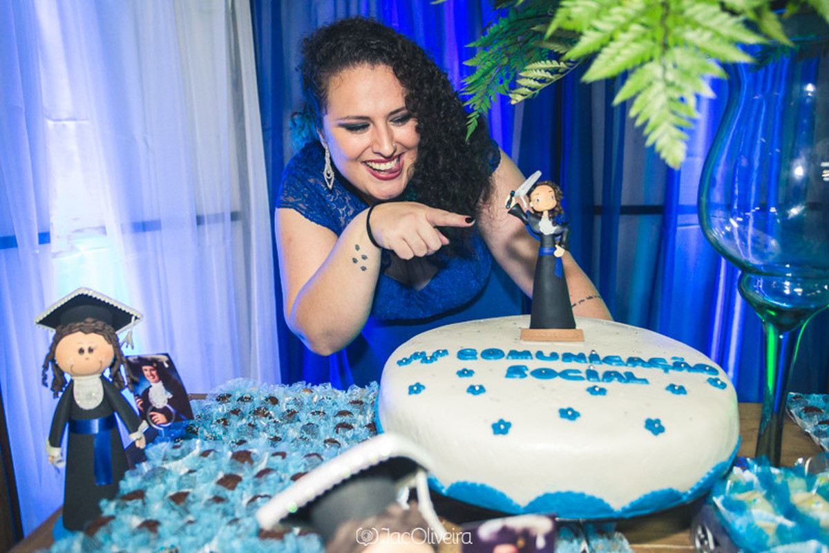 formanda apontando para bolo e boneca