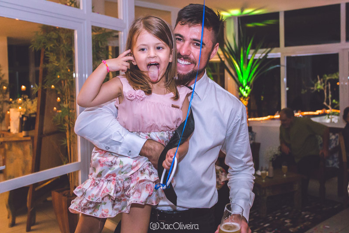 Guilherme Martini com afilhada colocando a lingua