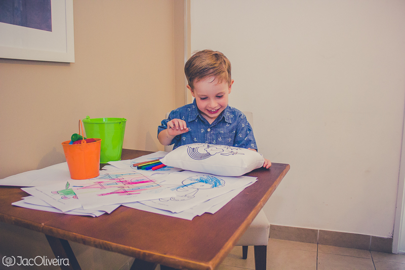 menino brincando com almofada