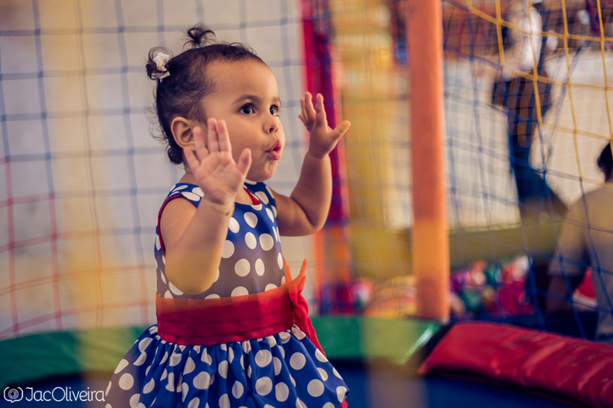 fotografia da menina na cama elástica com vestido de galinha pintadinha