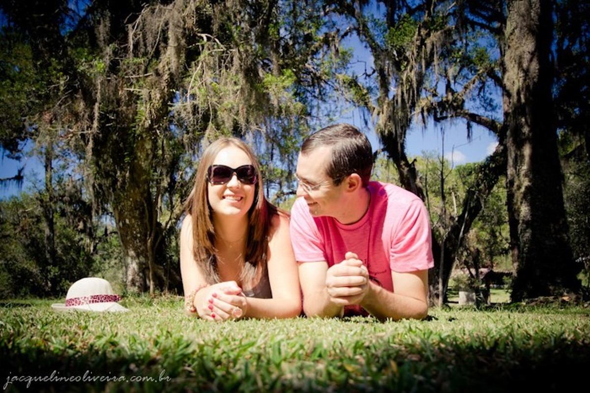 casal deitado de bruços na grama
