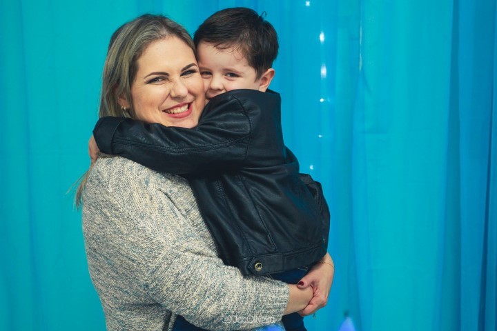 mãe com menino no colo abraçando apertado