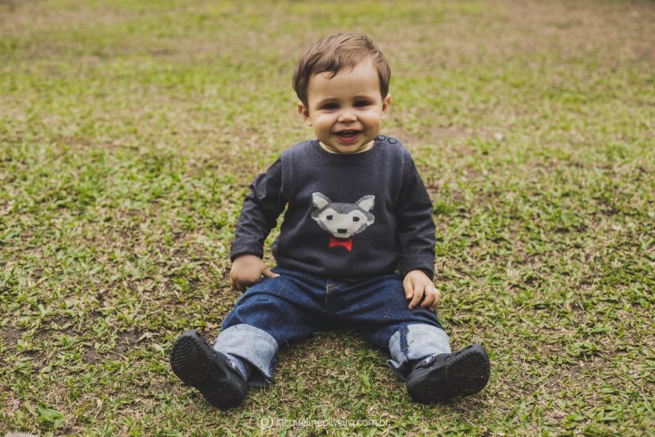 fotografia de menino sentado na grama