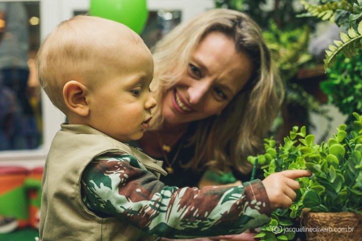 menino mexendo na decoração com mãe olhando