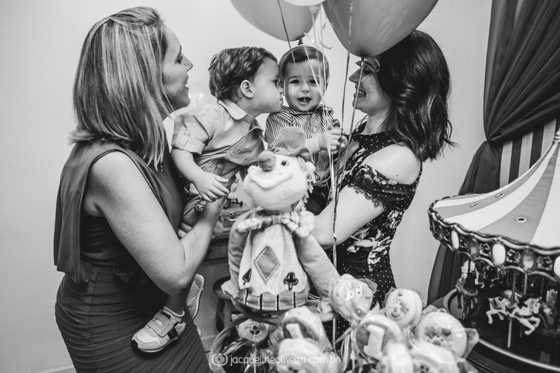 foto preto e branco da dinda com o bebê nos balões