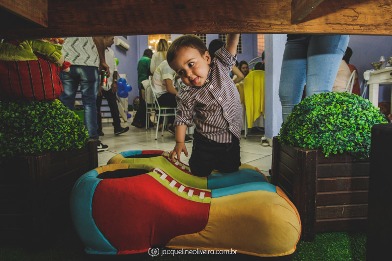 foto do menino embaixo da mesa do bolo