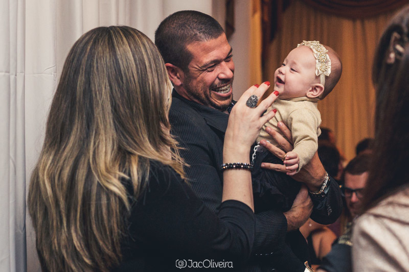 foto da mãe brincando com menina no colo do tio