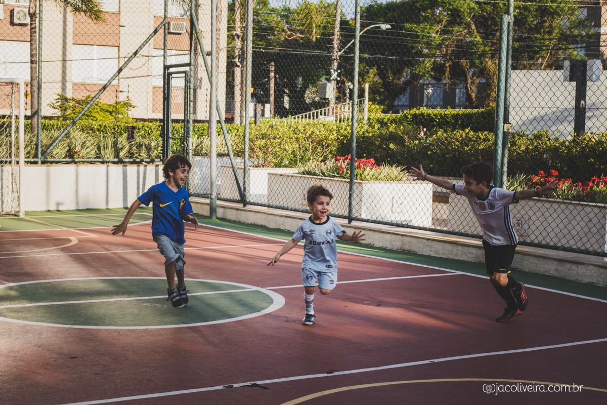 fotografo em porto alegre meninos correndo na quadra de futebol