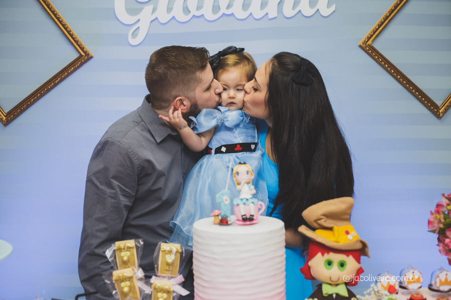 fotografo em porto alegre festa infantil pais beijando menina atrás do bolo