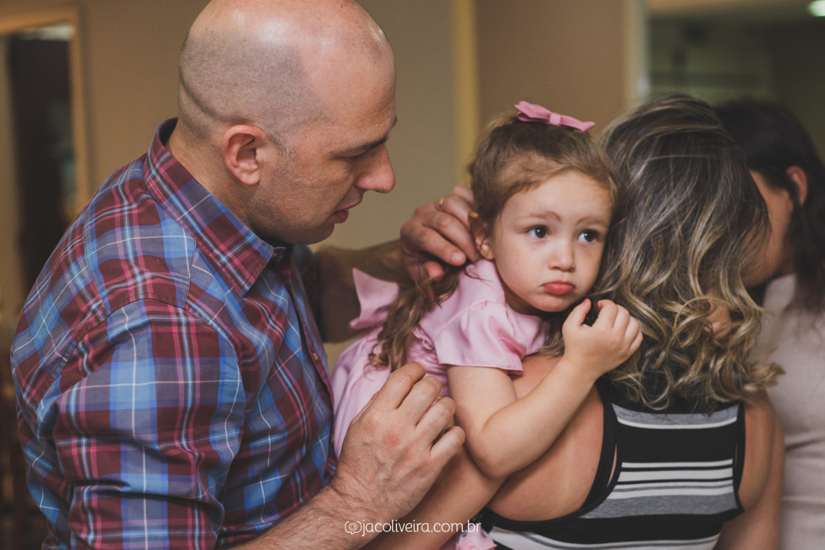 julia no colo dos pais no final da festa