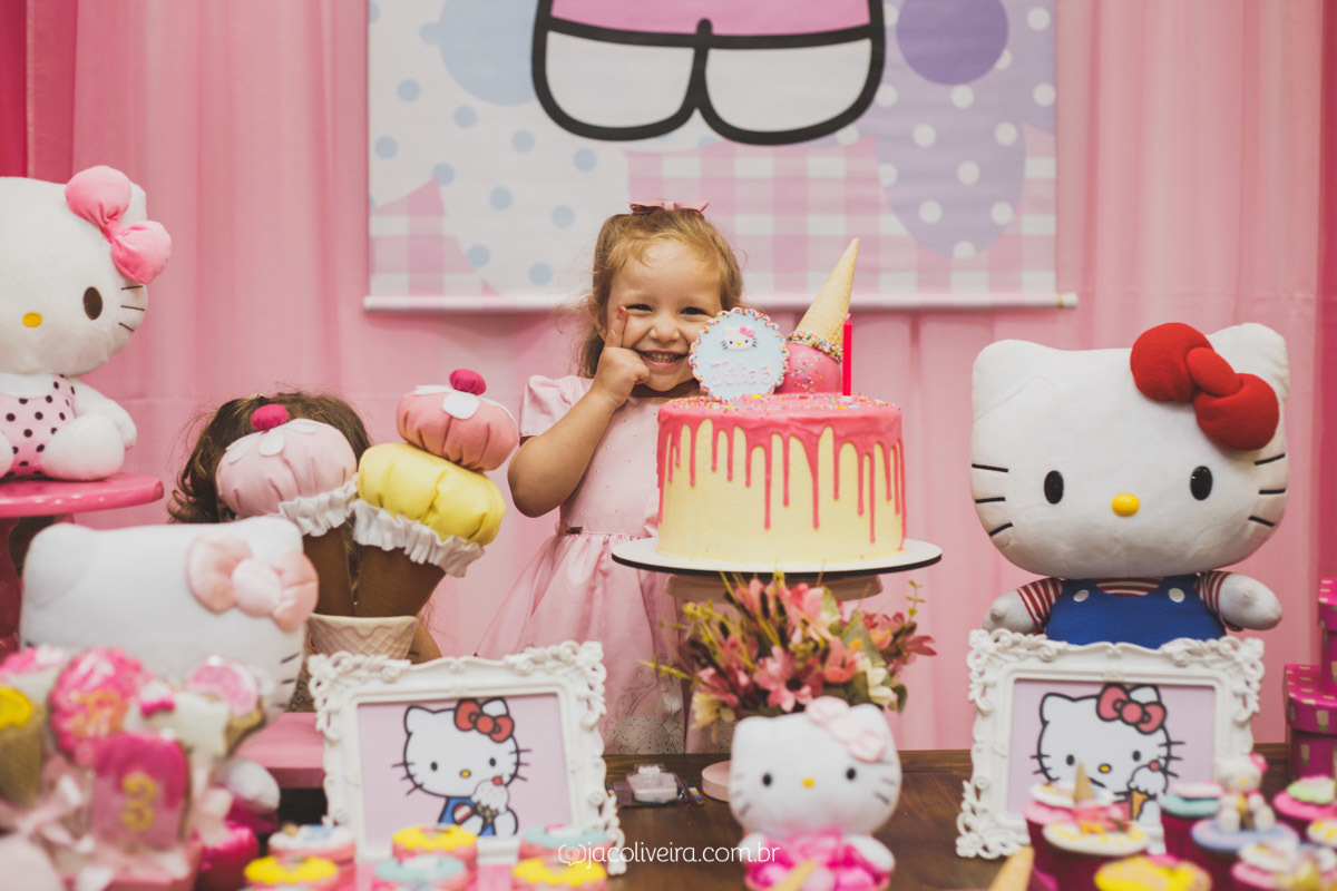 julia posando com o bolo rosa e amarelo da hello kitty fotografo festa infantil porto alegre
