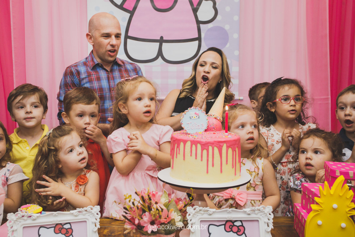 parabens e assoprar a velinha mesa do bolo decoração hello kitty rosa fotografo festa infantil porto alegre