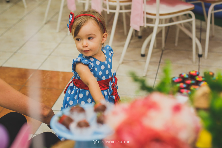 ana julia olha decoração da mesa em seu aniversário
