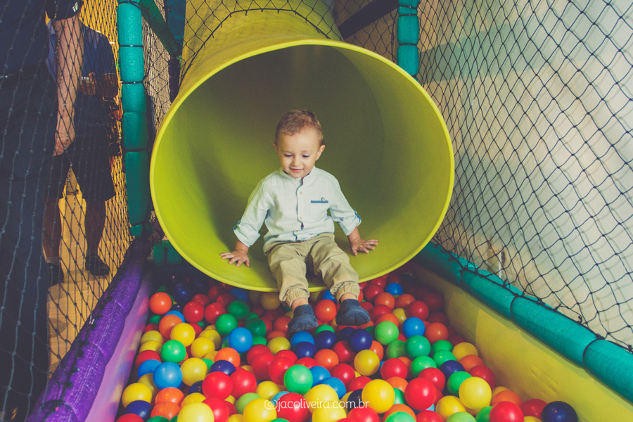 fotografo infantil menino descendo escorrega na piscina de bolinhas