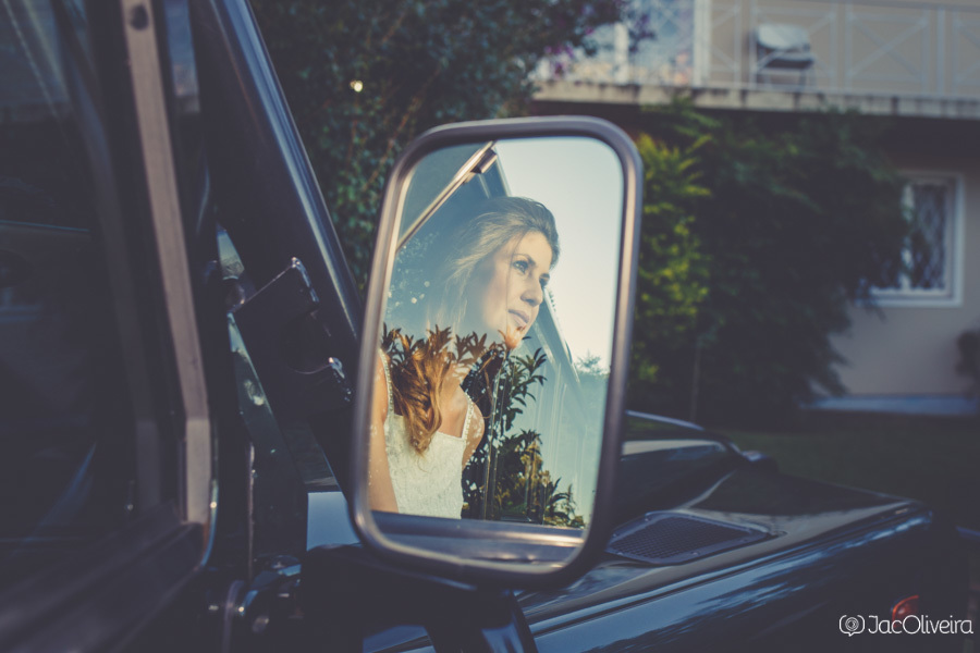 noiva olhando para o horizonte no espelho da land rover antes de ir para o casamento em canela