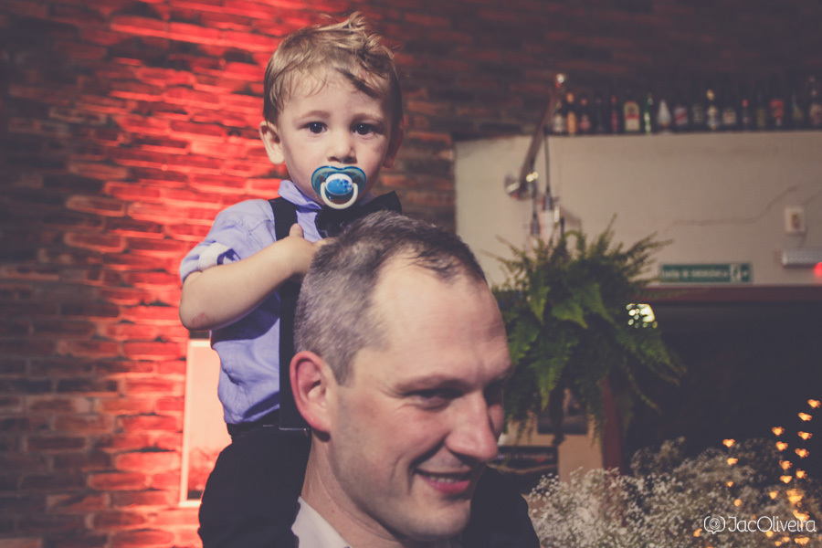 criança nos ombos do pai na festa de casamento