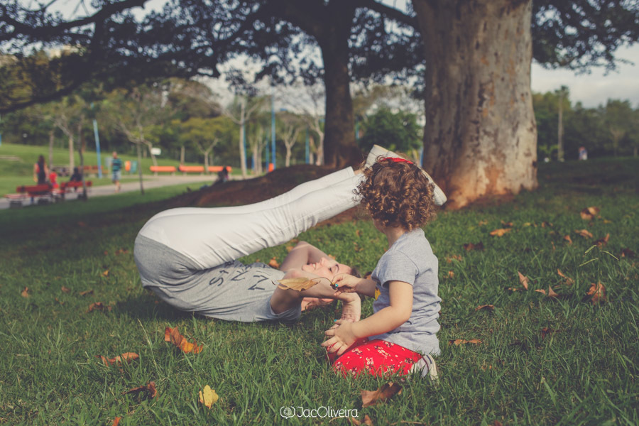 mãe e filha rolando na grama e folhas