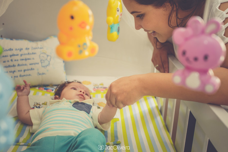mãe segura mão do bebê no berço fotografa em porto alegre