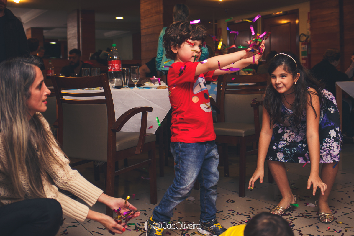 criança brincando com papel picado em seu aniversário