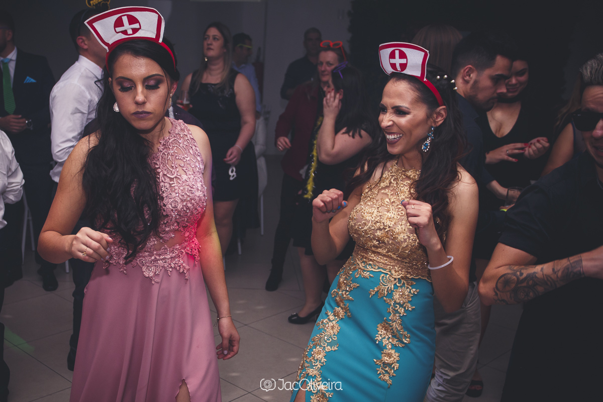 formanda de vestido rosa e vestido azul com dourado dançando na pista em novo hamburgo