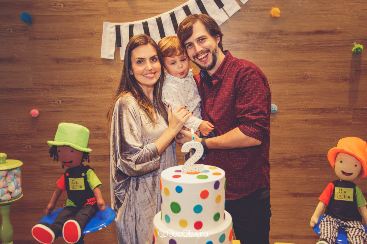pais com filho no aniversário de 2 anos decoração colorida e bolo fake