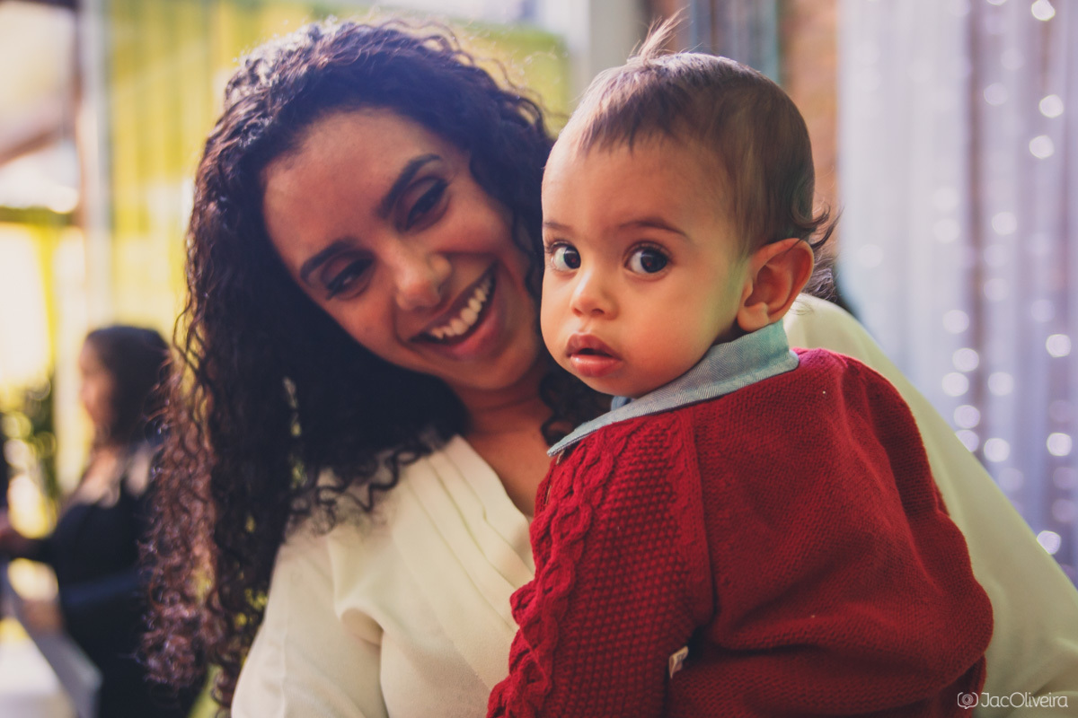 mãe e filho no colo olhando para a camera no aniversário de 1 ano 