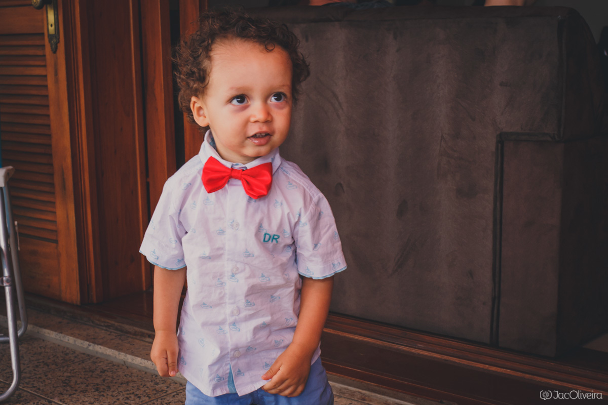 fotos menino com gravata borboleta após batizado