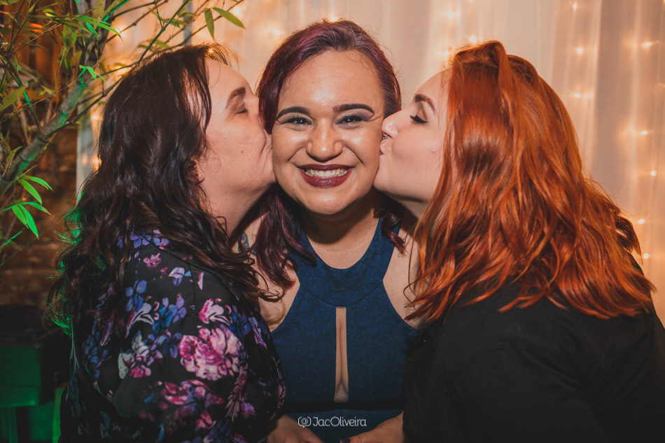 mãe e irmã beijam bochecha da formanda karen 