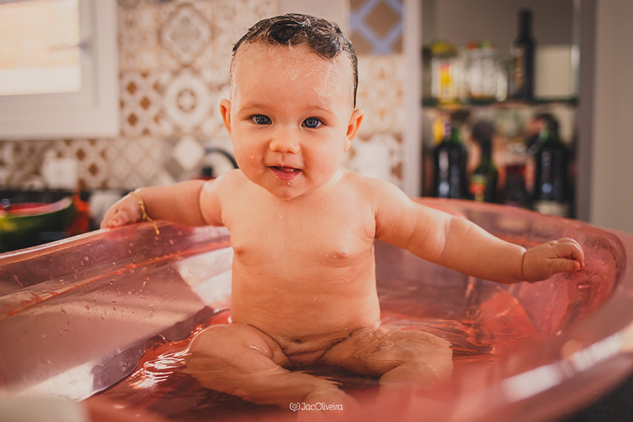 bebê menina tomando banho de banheira na cozinha de casa; fotógrafa em porto alegre