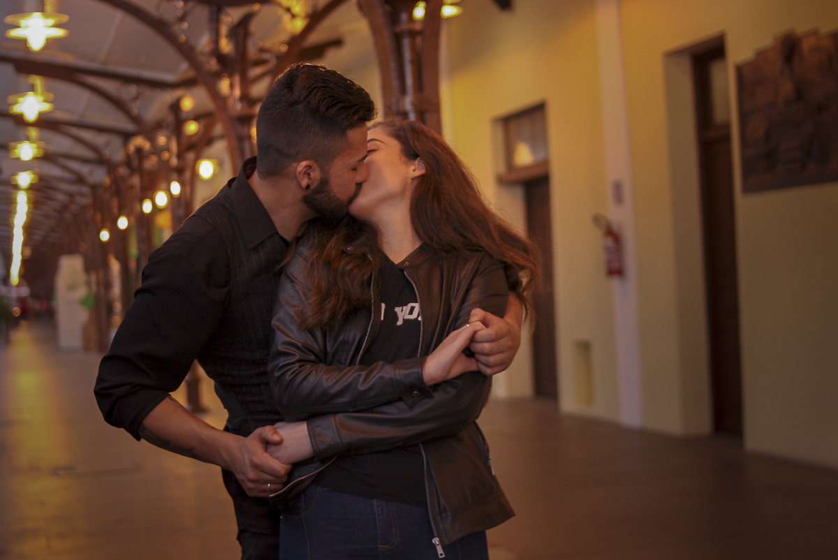 CASAL SE BEIJANDO NA ESTAÇÃO DE TREM