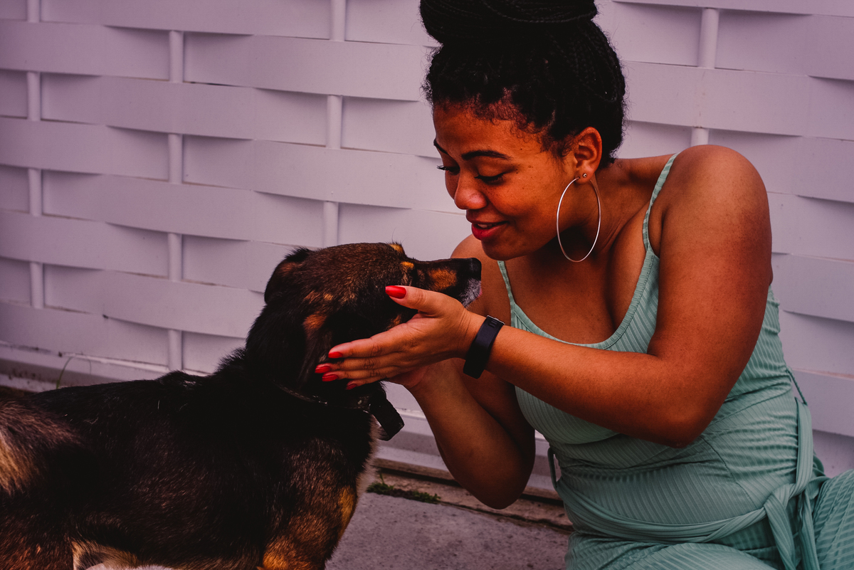 foto da modelo brincando com um cachorrinho de rua