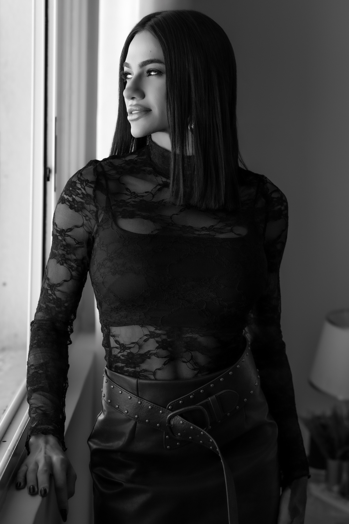 Ensaio feminino Curitiba. Mulher com roupa rendada em pé, pose confiante, fundo cinza neutro. Marco Lourenço Fotografia.