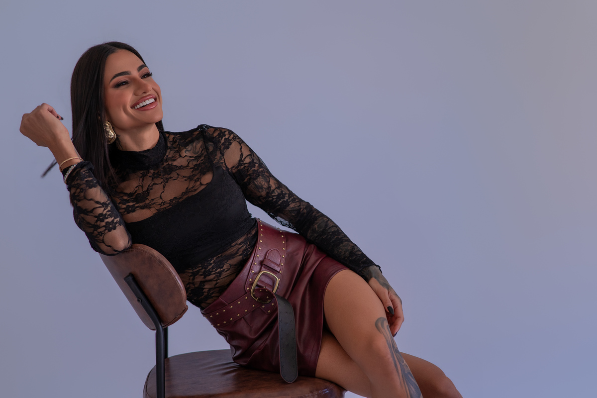 Ensaio feminino estúdio Curitiba. Pose descontraída com roupa rendada, expressão alegre e espontânea. Marco Lourenço Fotografia.