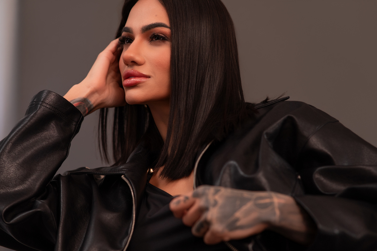 Detalhe de pose com jaqueta de couro, tatuagem visível, iluminação flash. Marco Lourenço