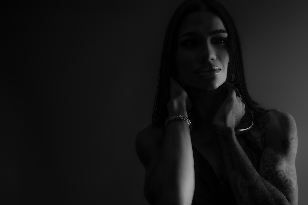 Fotografia feminina preto e branco estúdio Curitiba. Close expressivo, luz dramática, estilo editorial. Marco Lourenço.