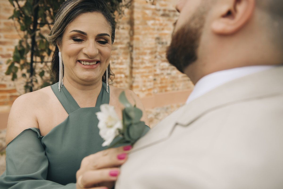 noivo e a mae quase prontos para o casamento ao ar livre