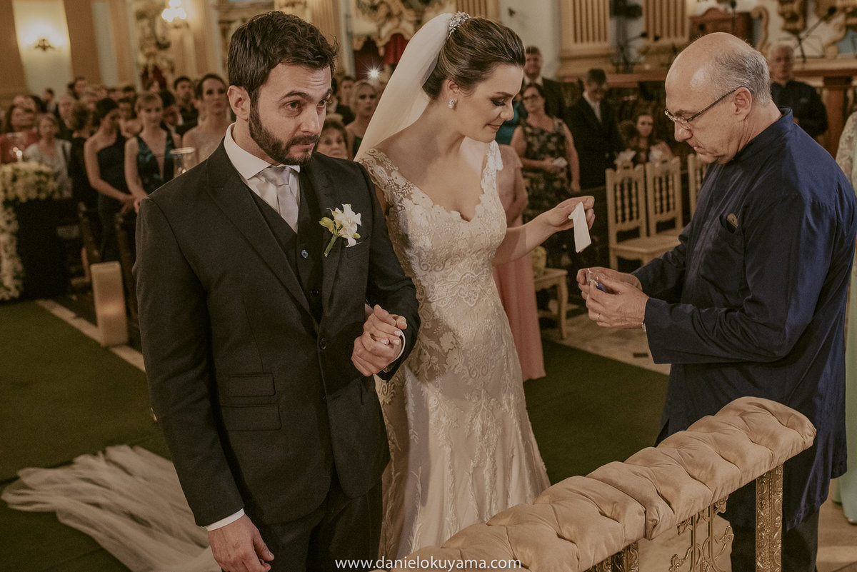 a benção do padre com as alianças antes de entregara para o casal