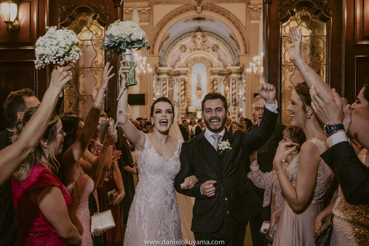 saída dos noivos com muita alegria e descontração ao fundo a bela catedral de campinas a igreja mais bonita para casamentos no interior de sp